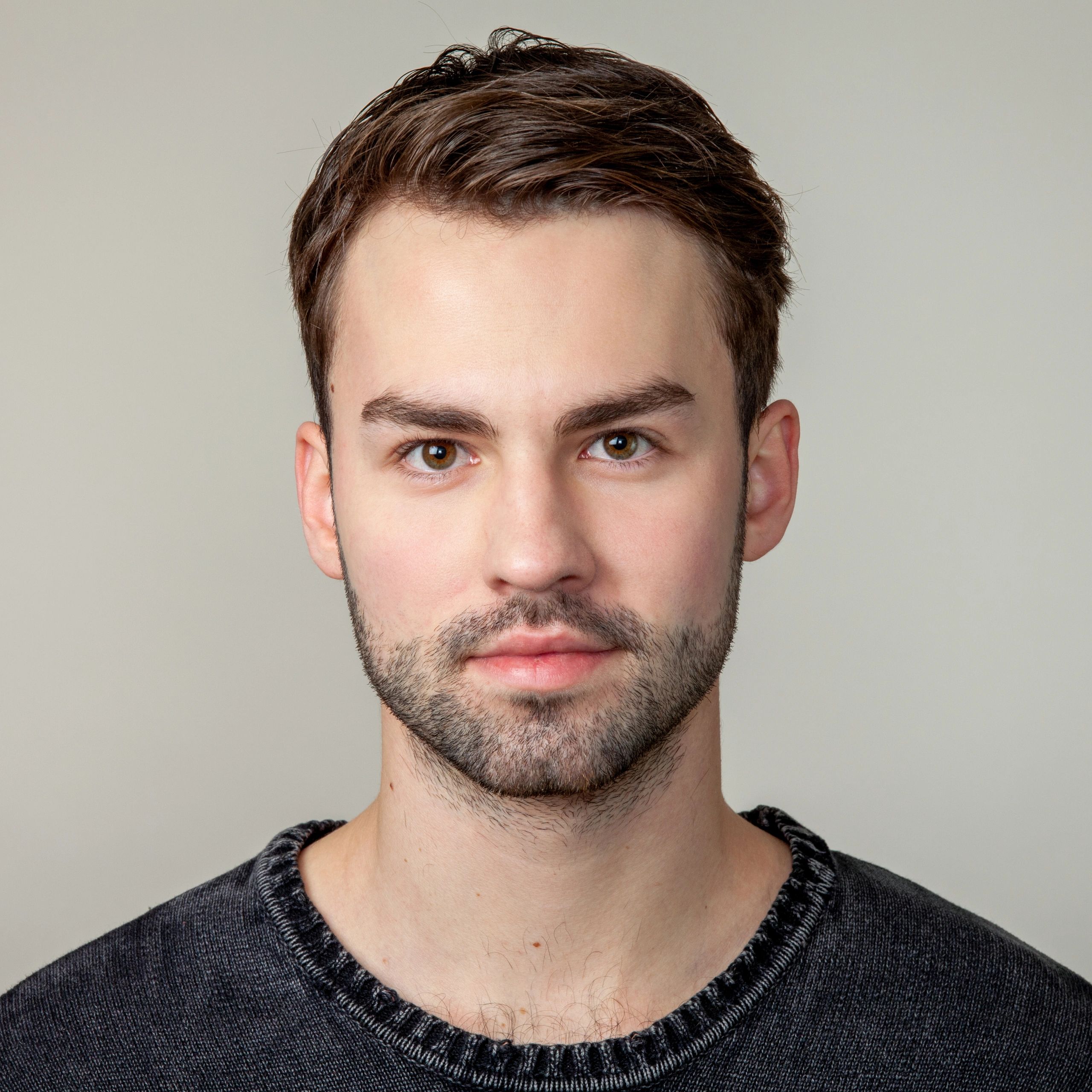 Professional headshot of a bearded man on a neutral background