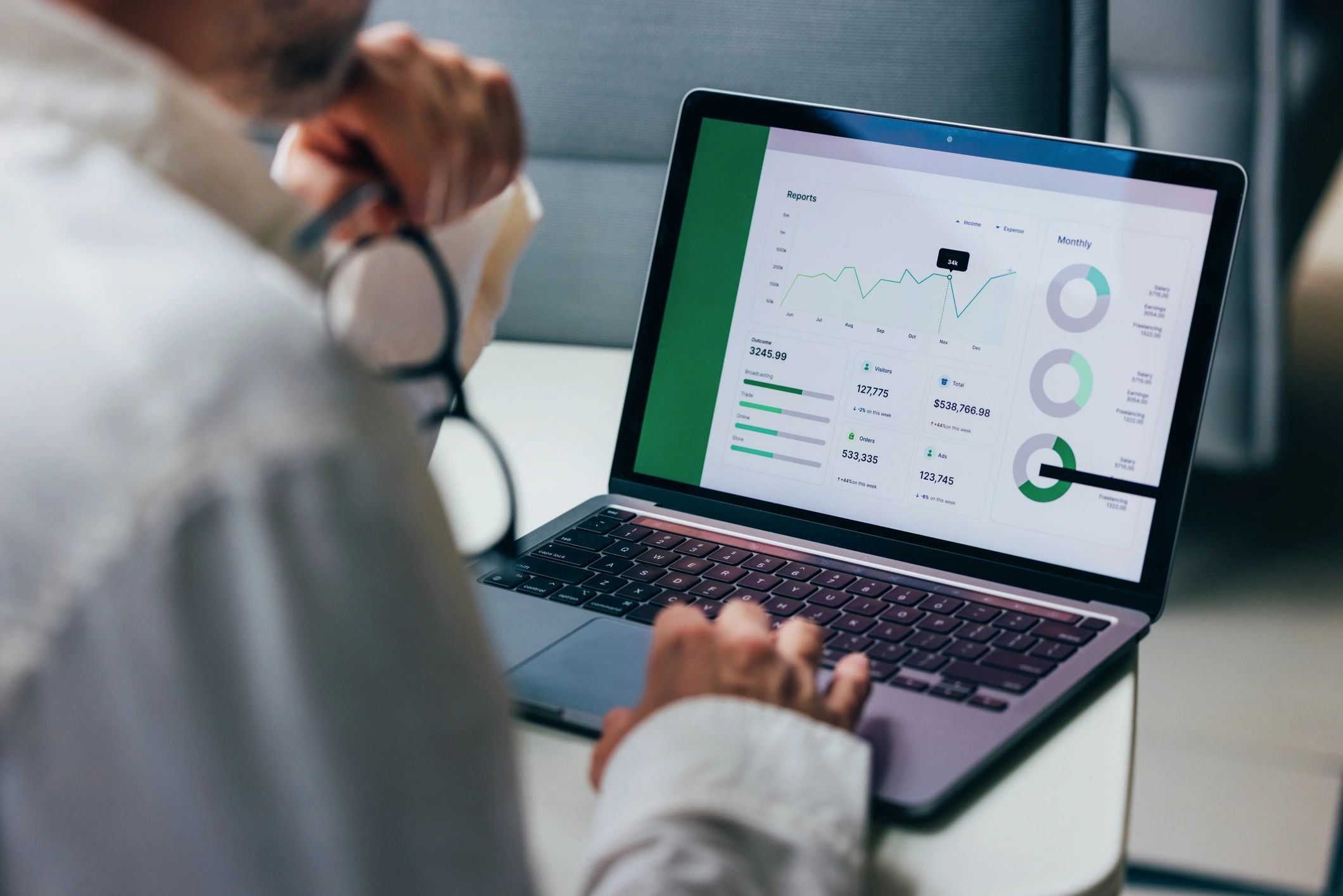 Professional analyzing procurement data on a laptop with charts and reports
